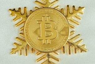 A gold Bitcoin on top of a gold snowflake