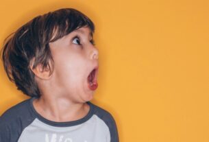 A young boy is screaming on a yellow background